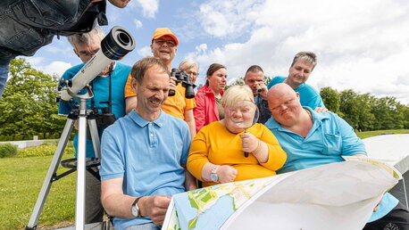 Eine Gruppe von Menschen  mit Unterstützungsbedarf schaut sich einen Stadtplan an.